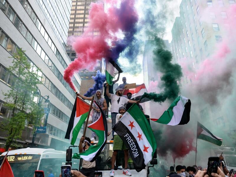 Demonstrators hold Palestine and Syrian flags in support of Palestine in midtown Manhattan, New York City