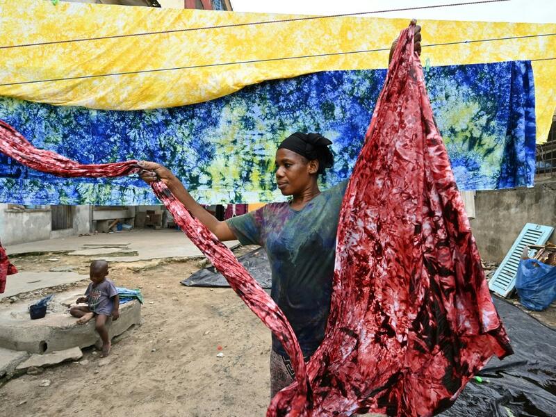 Dyers dye cotton fabric at Pathe'O house in the popular district of Treichville in Abidjan on March 31, 2021. A small self-taught tailor in his early years, the Ivorian-Burkinabe Pathe'O became the designer of African heads of state and celebrates the fiftieth anniversary of his brand, leading the "fight" for the recognition of fashion on the continent. 