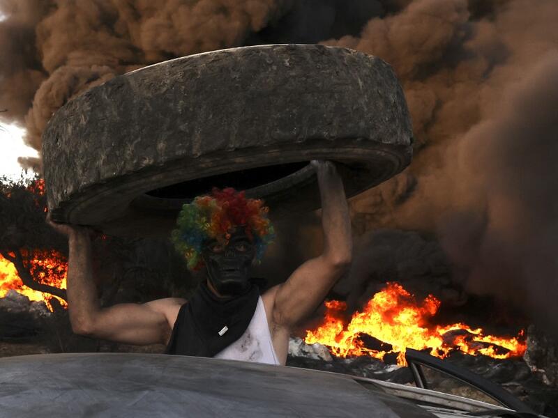 Palestinians burn tires during a night demonstration against the expansion of the Jewish settlement outpost of Eviatar on the lands of Beita village, near the occupied West Bank city of Nablus