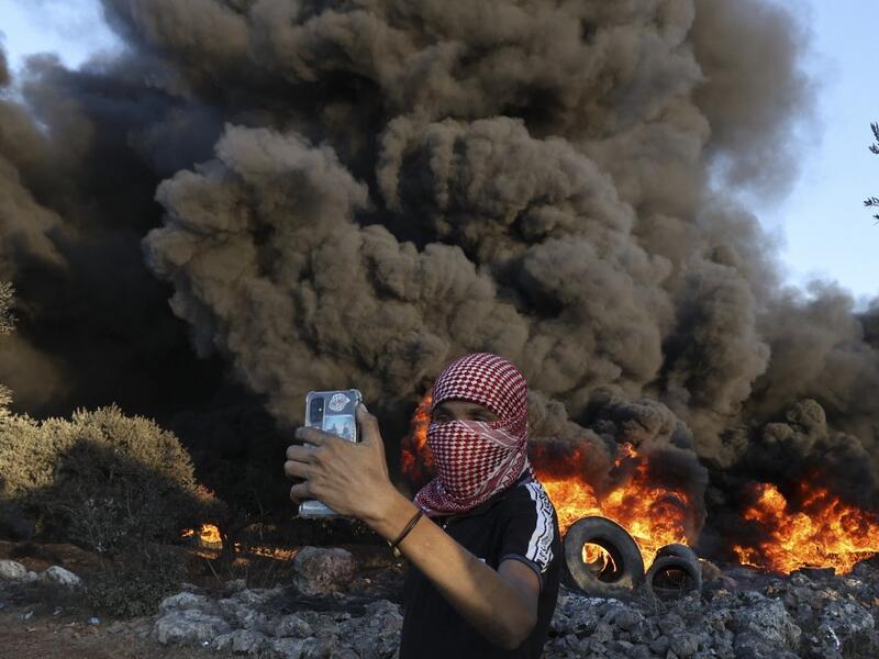Palestinians burn tires during a night demonstration against the expansion of the Jewish settlement outpost of Eviatar on the lands of Beita village, near the occupied West Bank city of Nablus