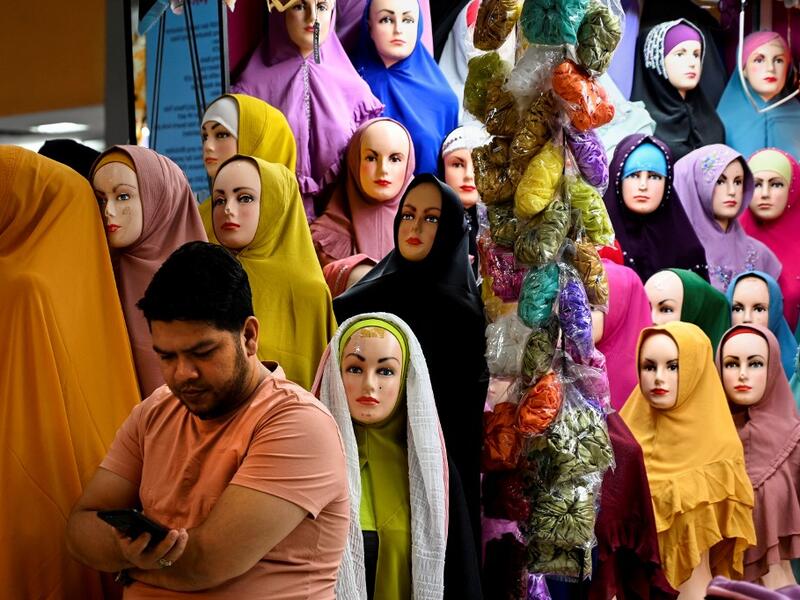 A vendor waits for customers at a shopping centre ahead of Eid al-Adha celebrations in Banda Aceh on July 17, 2021. CHAIDEER MAHYUDDIN / AFP