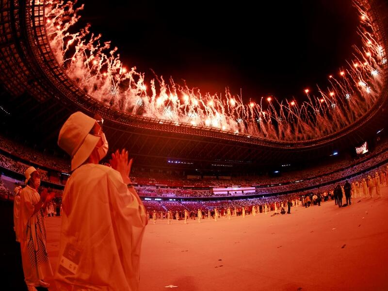 A volunteer reacts during a fireworks display at the end of the opening ceremony of the Tokyo 2020 Olympic Games, at the Olympic Stadium, in Tokyo