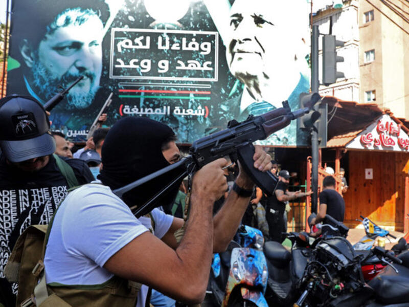 A Hezbollah fighter fires his gun 