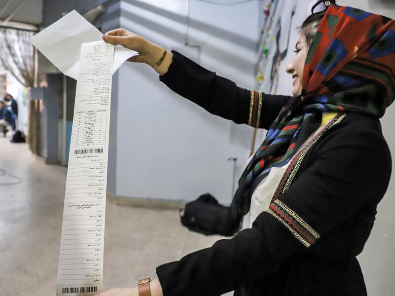 An Iraqi election official holds a printout of the electronic count of votes at a polling station in the northeastern city of Sulaymaniyah in Iraq's autonomous Kurdistan region during the early parliamentary elections on October 10, 2021. (Photo by Shwan MOHAMMED / AFP)