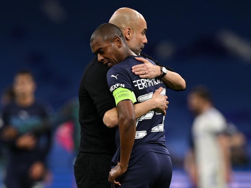 Manchester City's Spanish manager Pep Guardiola (L) hugs Manchester City's Brazilian midfielder Fernandinho after the UEFA Champions League semi-final second leg football match between Real Madrid CF and Manchester City at the Santiago Bernabeu stadium in Madrid on May 4, 2022. Real Madrid won the match 3-1. (Photo by Paul ELLIS / AFP)