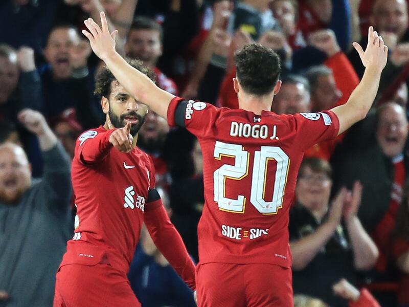 Liverpool's Egyptian striker Mohamed Salah (L) celebrates scoring his team's first goal with Liverpool's Portuguese striker Diogo Jota (back) during the UEFA Champions League group A football match between Liverpool and Ajax at Anfield in Liverpool, north west England on September 13, 2022. (Photo by Lindsey Parnaby / AFP)