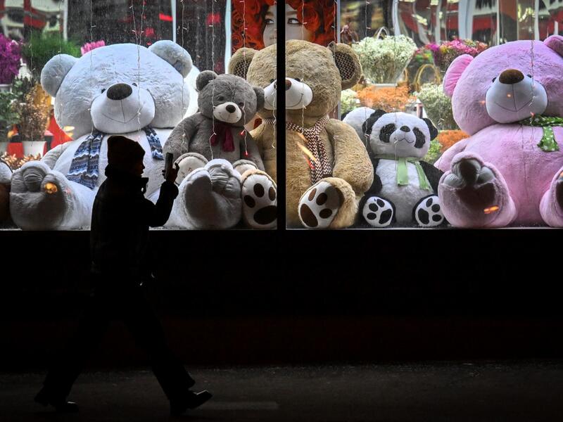 A pedestrian walks past a shop window with teddy bears as decoration ahead of the New Year and Christmas festivities in Moscow on December 26, 2022. (Photo by Yuri KADOBNOV / AFP)