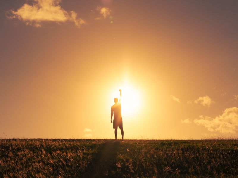 Strong determined man putting fist up to the sky. Mental and physical strength concept.