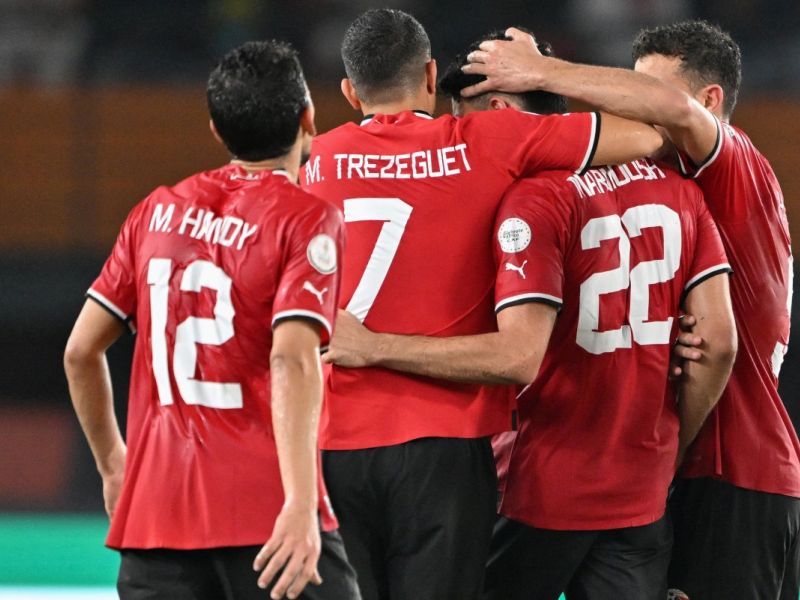 Egypt's forward #22 Omar Marmoush celebrates with teammates after scoring his team's first goal during the Africa Cup of Nations (CAN) 2024 group B football match between Egypt and Ghana at the Felix Houphouet-Boigny Stadium in Abidjan on January 18, 2024. (Photo by Issouf SANOGO / AFP)