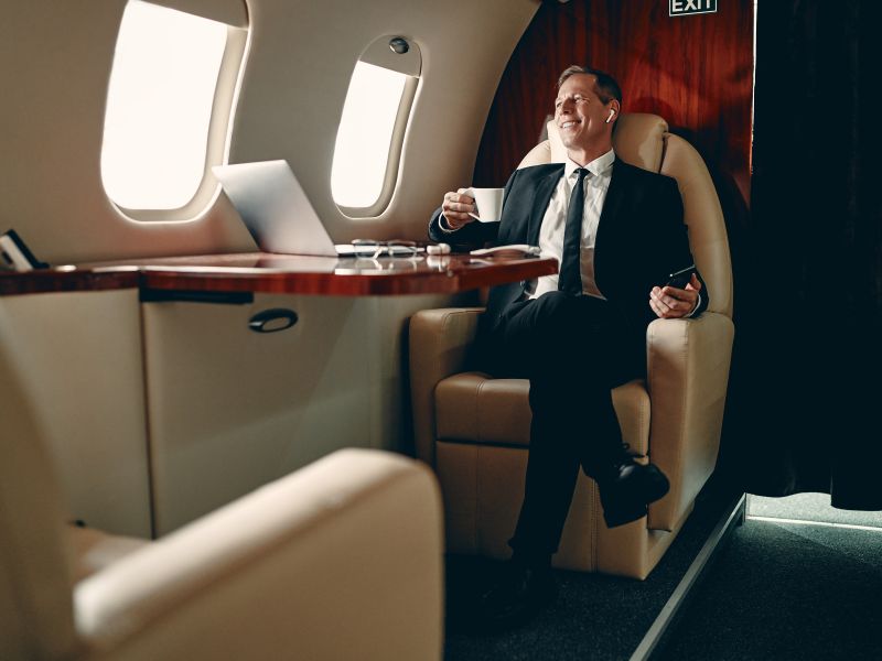 Senior businessman in suit flying in private jet