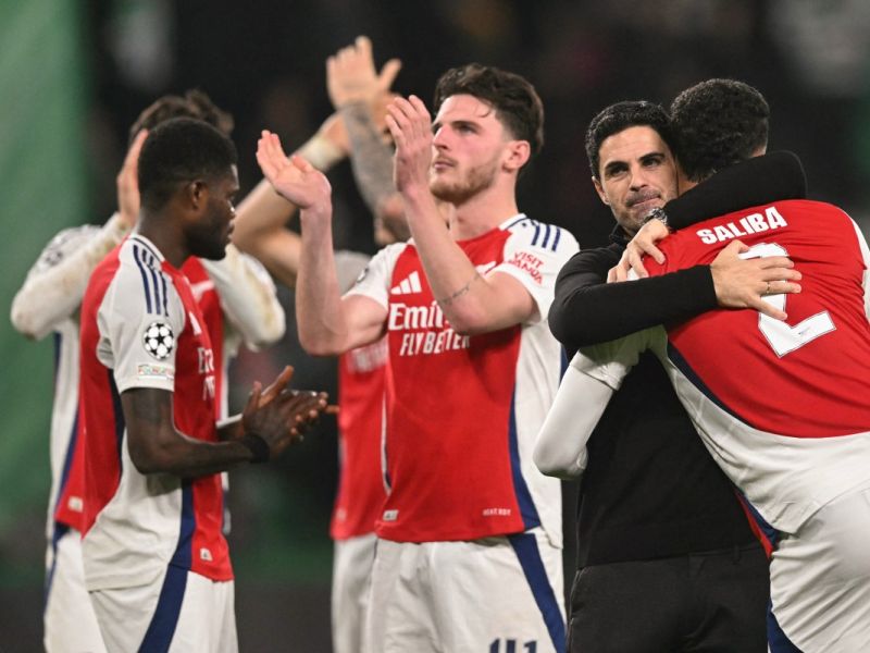 Arsenal's Spanish coach Mikel Arteta (2R) hugs Arsenal's French defender #02 William Saliba at the end of the UEFA Champions League, league phase day 5 football match between Sporting CP and Arsenal FC, at the Jose Alvalade stadium in Lisbon, on November 26, 2024. (Photo by PATRICIA DE MELO MOREIRA / AFP)