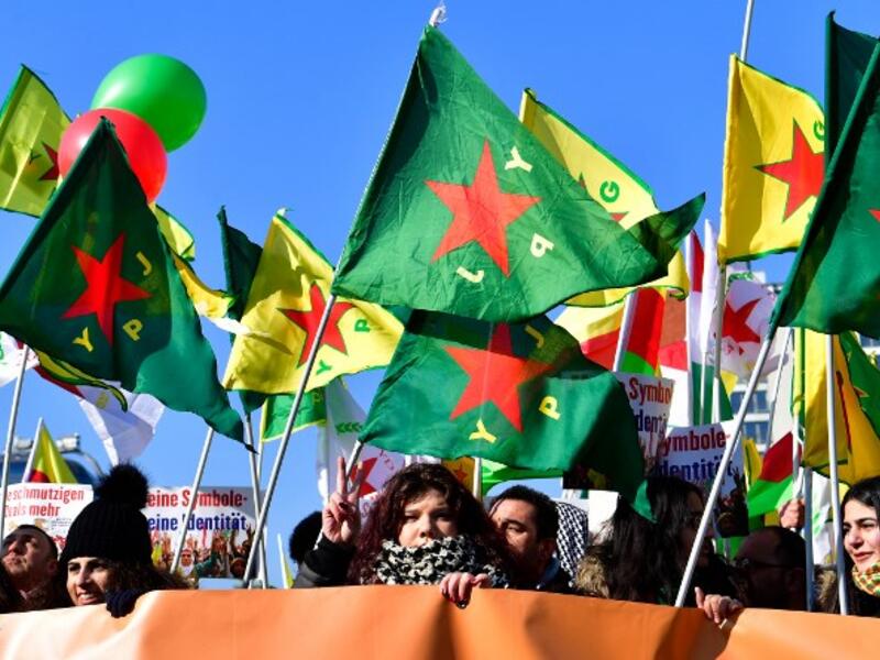 Protesters hold flags of the mainly-Kurdish militia in Syria, the People's Protection Units (YPG, yellow flags), and of its female equivalent, the Women's Protection Units (YPJ, green flags). 
(John MACDOUGALL / AFP)