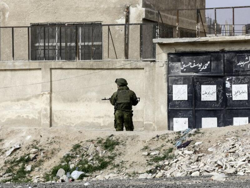 A member of the Russian military police stands guard at the Wafideen checkpoint on the outskirts of the Syrian capital Damascus neighboring the rebel-held Eastern Ghouta enclave on Mar. 13, 2018, awaiting any civilians evacuating from the area.  (Louai Beshara / AFP)