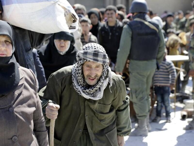 Syrian civilians, evacuated from rebel-held areas in the Eastern Ghouta, gather at a school in the regime-controlled Hosh Nasri, on the northeastern outskirts of the capital Damascus on Mar.16, 2018, ahead of being relocated to other areas. (LOUAI BESHARA / AFP)
