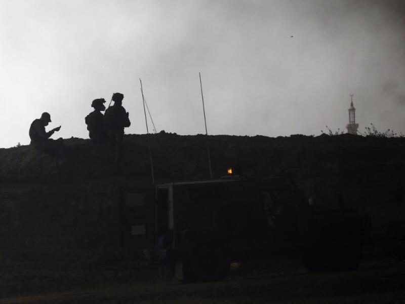 Israeli security forces are deployed near Kibbutz Nir Oz on the Israeli border with the southern Gaza Strip as smoke billows from tyres burning in the Palestinian village of Khuzaa on Apr. 6, 2018. Clashes erupted as protesters gathered along the Gaza border a week after similar demonstrations led to violence in which Israeli force killed 19 Palestinians, the bloodiest day since a 2014 war.
(Menahem KAHANA / AFP)