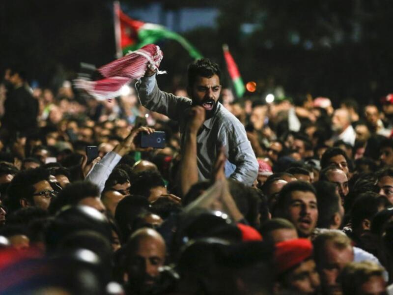 Jordanian protesters shout slogans and raise a national flag during a demonstration outside the Prime Minister's office in the capital Amman late on June 2, 2018. 
Khalil MAZRAAWI / AFP