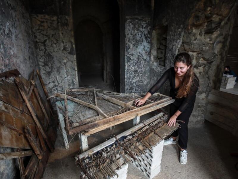 Woman touching the remains of a destroyed piano in a room at the Sofar Grand Hotel in the Lebanese village of Sofar, some 30 kilometres (20 miles) east of Beirut (AFP)