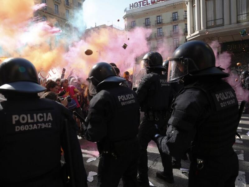 Protesters throw paint and coloured powder to Catalan regional police 'Mossos D'Esquadra' officers during a counter-protest against a demonstration in support of Spanish police in Barcelona on September 29, 2018. 
Pau Barrena / AFP