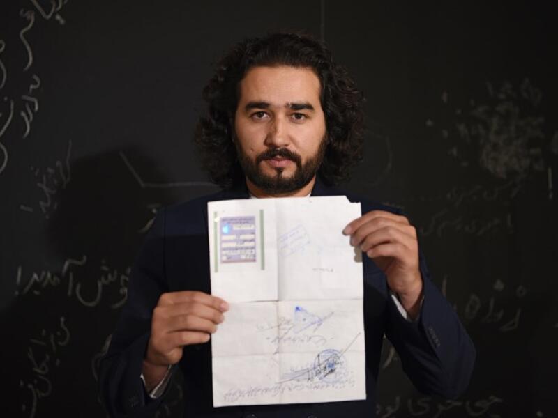 In this photo taken on October 8, 2018, Afghan co-founder and president of ArtLords Omaid Sharifi, 32, poses for a picture as he holds his id card or Tazkira registered to vote in the upcoming parliamentary election, in Kabul. 
WAKIL KOHSAR / AFP