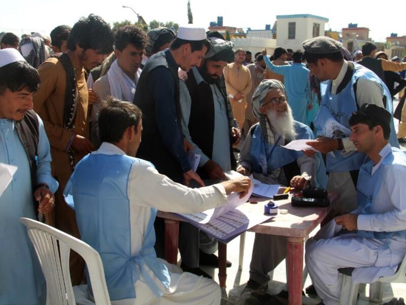 Afghan Independent Election Commission (IEC) officials prepare ballot papers for voters at a polling centre for the country's legislative election in Khost Province on October 20, 2018.
FARID ZAHIR / AFP