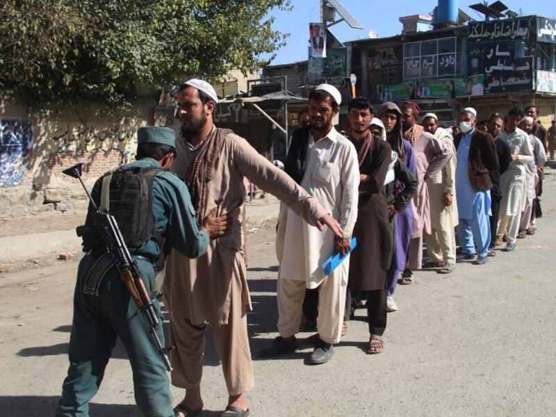 An Afghan policeman searches voters before casting their votes at a polling centre for the country's legislative election in Khost Province on October 20, 2018. 
FARID ZAHIR / AFP