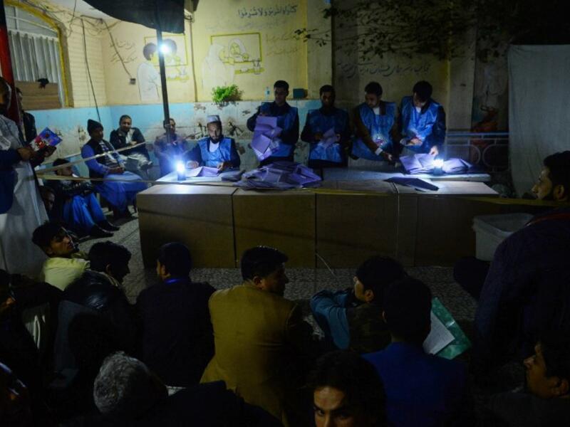 In this photo taken on October 20, 2018, Afghan Independent Election Commission (IEC) officials count ballot papers at a polling centre for the country's legislative election in Herat province. 
HOSHANG HASHIMI / AFP