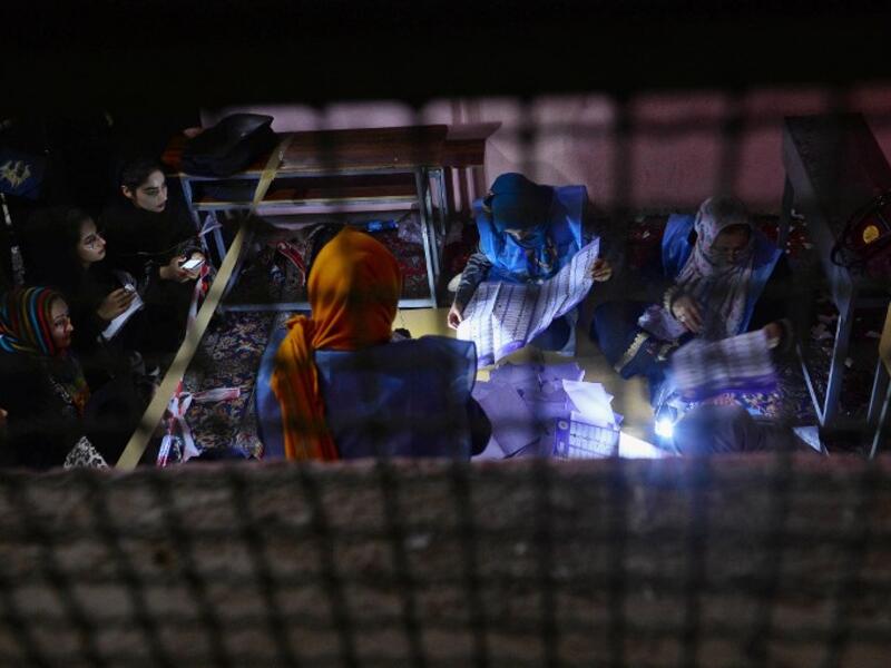 In this photo taken on October 20, 2018, Afghan Independent Election Commission (IEC) officials count ballot papers at a polling centre for the country's legislative election in Herat province. 
HOSHANG HASHIMI / AFP