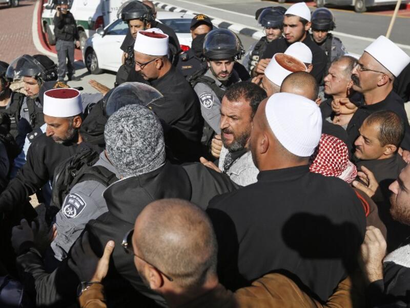 Israeli security forces stand guard as Druze men protest against municipal elections. (JALAA MAREY / AFP)