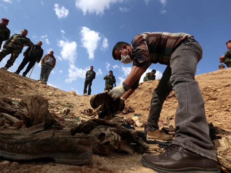 A members of the Yazidi minority search for clues, that might lead them to missing relatives in the remains of people killed by the Islamic State in Iraq. (Safin HAMED / AFP)