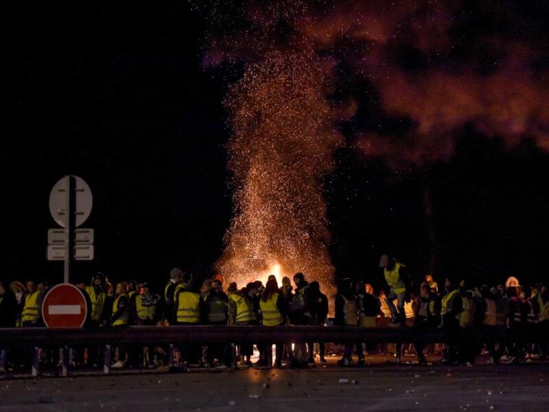 Protesters stand around a fire as they block the A10 motorway in Virsac, near Bordeaux, southwestern France, on November 18, 2018.
NICOLAS TUCAT / AFP