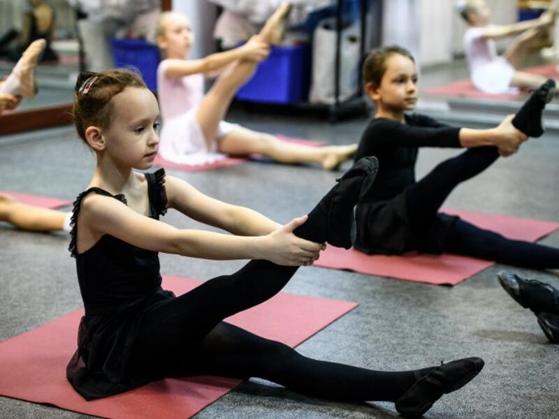 Girls attend a class at a ballet studio in Moscow on November 22, 2018. In a small studio in northern Moscow, parents and grandparents sit in a corridor waiting for children as young as three to finish their ballet class. 
Mladen ANTONOV / AFP