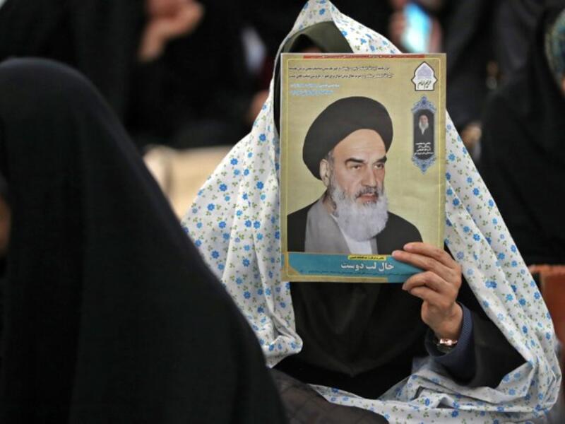 An Iranian woman holds a poster of Iran's late founder of the Islamic Republic, Ayatollah Ruhollah Khomeini
STR / AFP