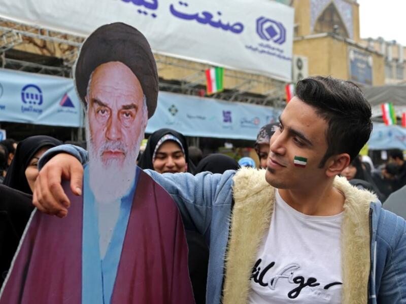 An Iranian man poses with a life-size cutout portrait of Islamic Revolution founder Ayatollah Ruhollah Khomeini during a ceremony celebrating the 40th anniversary of Islamic Revolution in the capital Tehran on February 11, 2019. 
ATTA KENARE / AFP