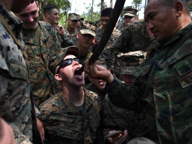 A Thai soldier holds a slaughtered snake while a US Marine drinks its blood during a jungle survival training in the joint 'Cobra Gold' military exercise in Chantaburi province 
Lillian SUWANRUMPHA / AFP