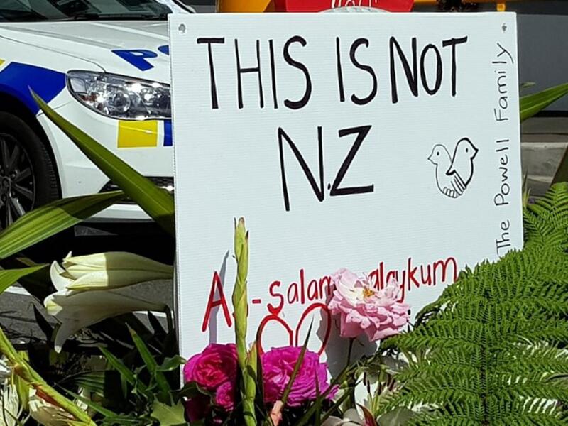A message is seen as residents pay their respects by placing flowers for the victims of the mosques attacks in Christchurch 
Glenda KWEK / AFP