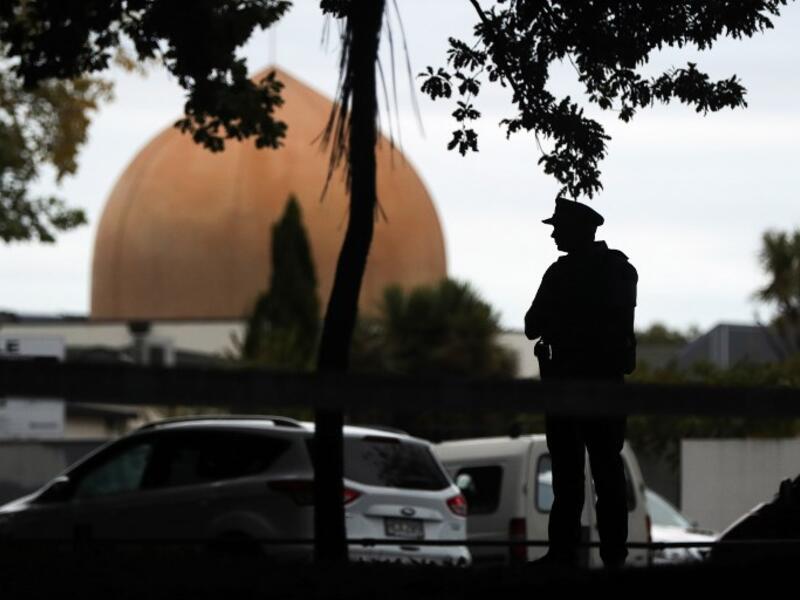 An armed policeman stands guard in front of the Masjid Al Noor Mosque in Christchurch (AFP)