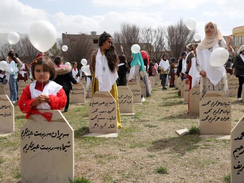 Iraqi-Kurds visit a grave site in Halabja near the monument for victims of the Halabja gas massacre 
Shwan MOHAMMED / AFP