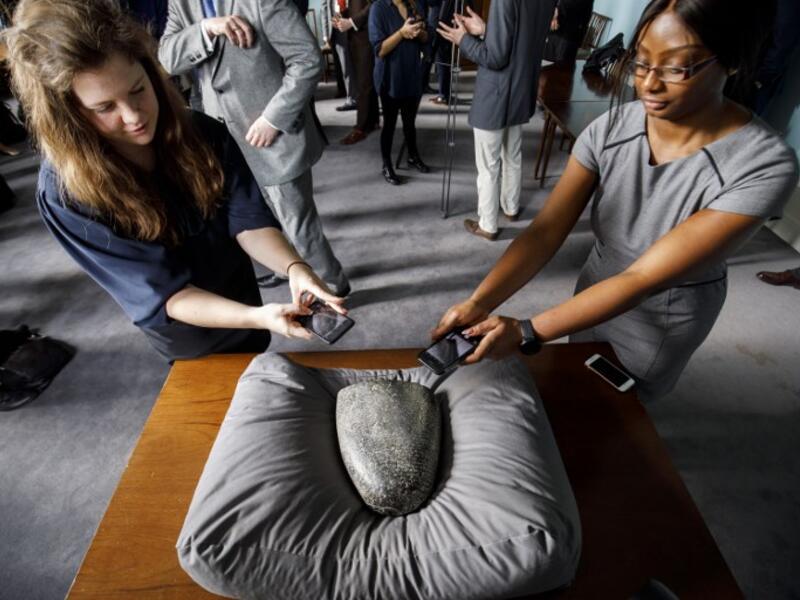 Members of the press take pictures of a Babylonian cuneiform kudurru (boundary stone) which was looted from Iraq on March 19, 2019 at the British museum in London (AFP)