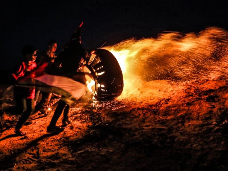 Palestinian protesters take part in a night demonstration near the fence along the border with Israel, in Rafah
SAID KHATIB / AFP