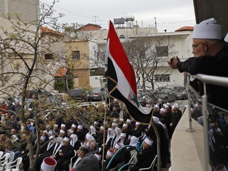 Druze residents of the Golan Heights wave Syrian flags as they protest against the backing of Israel's capture of the Golan Heights by the US president, in the village of Majdal Shams in the Israeli-annexed territory on March 23, 2019. 
Jalaa MAREY / AFP