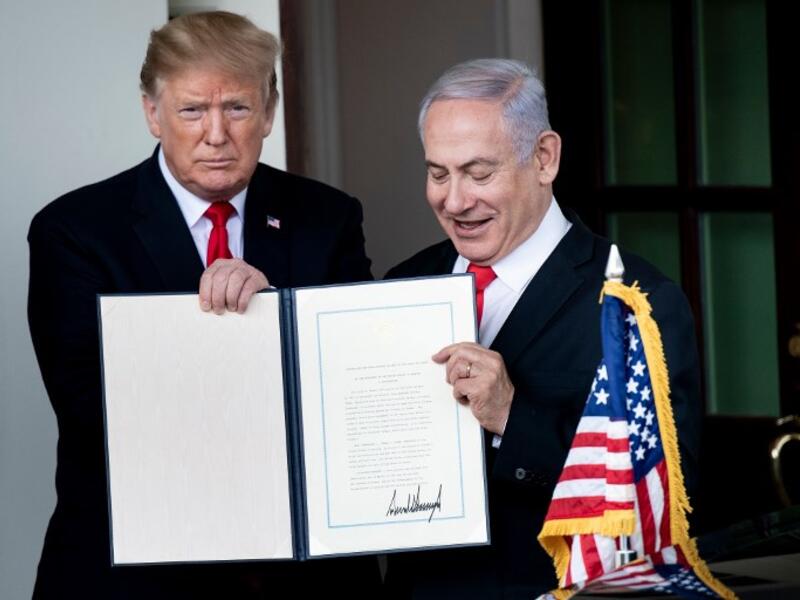 US President Donald Trump (L) and Israel's Prime Minister Benjamin Netanyahu hold up a Golan Heights proclamation outside the West Wing after a meeting in the White House March 25, 2019 in Washington, DC. 
Brendan Smialowski / AFP
