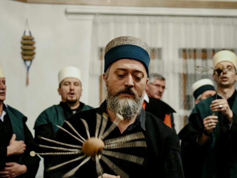 A Kosovo Dervish, adept of Sufism, a mystical form of Islam, swirls a needle before piercing his cheek during a ceremony in a prayer room
Gent SHKULLAKU / AFP