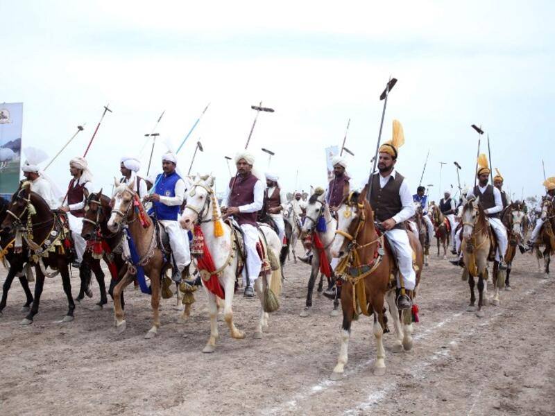 This photograph taken on March 27, 2019, shows Pakistani horse riders with lances used to pick up pegs during an attempt for a Guinness World Record for tent pegging in Khanewal district in Punjab province. 
SS MIRZA / AFP
