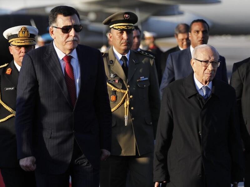 Tunisian President Beji Caid Essebsi (R) welcomes Libya's Prime Minister Fayez al-Sarraj upon his arrival at Tunis-Carthage international airport on March 30, 2019, to attend the Arab Summit tomorrow. 
Hussein Malla / POOL / AFP