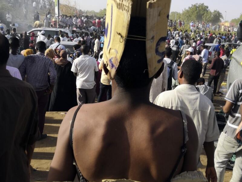 A Sudanese protester with a bare back walks with a sign behind reading in Arabic "Just fall that is all" during a demonstration in front of the military headquarters in the capital Khartoum on April 9, 2019.
AFP