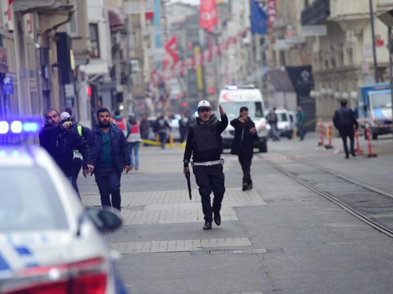 Turkish police push people away just after an explosion on the pedestrian Istiklal avenue in Istanbul on March 19, 2016. (AFP/Bulent Kilic)