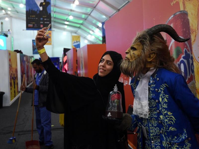 A Saudi woman uses her cell phone to take a "selfie" photograph with a cosplayer dressed as the Beast from Disney's 2017 live-action "Beauty and the Beast" film, as they attend the first ever Comic-Con Arabia event held in the capital Riyadh on November 25, 2017. 
(FAYEZ NURELDINE / AFP)