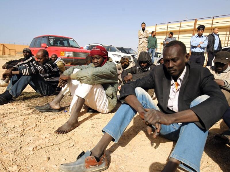 Sub-Saharan migrants sit at the Qanfouda detention center, in the southern outskirts of Benghazi, before being repatriated, on Dec. 2, 2017. 
(Abdullah DOMA / AFP)