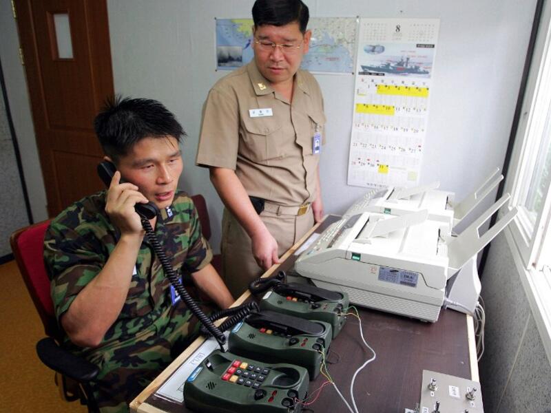 This file photo taken on Aug. 10, 2005 shows South Korean Lieutenant Choi Don-Rim (L) communicating with a North Korean officer during a phone call at a military office as the two countries tested a hotline aimed at helping avoid naval confrontations in the Yellow Sea (AFP/File)