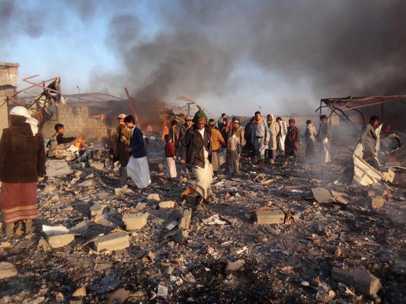 Smoke rises as Yemenis inspect the damage at the site of air strikes in the northwestern Huthi-held city of Saada, on Jan. 6, 2018 (STRINGER / AFP)